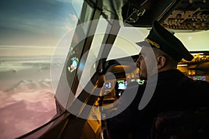 Caucasian bearded man controls the plane and looks at the beautiful sunset sky.