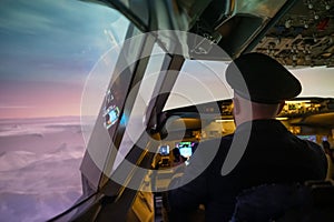 Caucasian bearded man controls the plane and looks at the beautiful sunset sky.