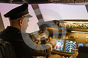 Caucasian bearded man controls the plane and looks at the beautiful sunset sky.