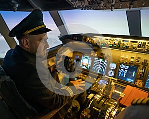 Caucasian bearded man controls the plane and looks at the beautiful sunset sky.