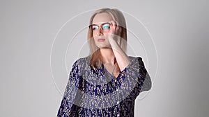 caucasian beautiful woman with blond hair trying different glasses. Eye glasses store concept. Bad vision medical