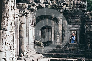 Caucasian blonde woman discovering the ruins of Angkor Wat temple complex in Siem Reap, Cambodia