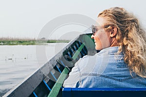 Caucasian blonde woman having a boat ride on Inle lake, Myanmar