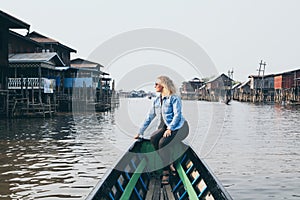 Caucasian blonde woman having a boat ride on Inle lake, Myanmar