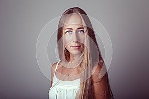 Caucasian blonde young beautiful girl woman model with long hair and blue eyes in white dress