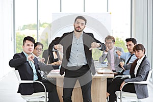 Caucasian boss businessman showing thumb down or dislike with unhappy face with unsuccess multiethnic business team and business photo