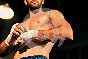 Caucasian boxer portrait wrapping his hand. Impetus