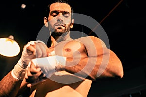 Caucasian boxer portrait wrapping his hand. Impetus