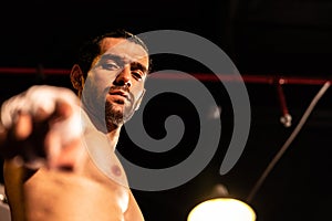 Caucasian boxer punch his bare fist and wrap posing. Impetus