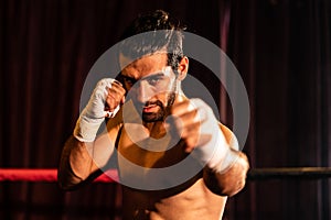 Caucasian boxer punch his bare fist and wrap posing. Impetus