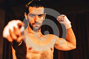 Caucasian boxer punch his bare fist and wrap posing. Impetus