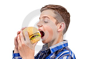 Caucasian boy eating burger and hamburger on white background,  bun
