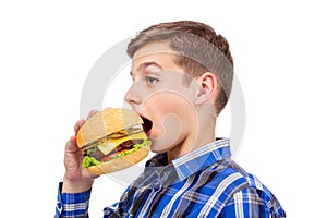 Caucasian boy eating burger and hamburger on white background,  meat