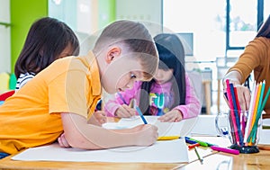 Caucasian boy ethnicity kid smiling white learning in classroom with friends and teacher  in kindergarten school, education