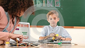 Caucasian boy fixing main board by using screwdriver at stem lesson. Pedagogy.