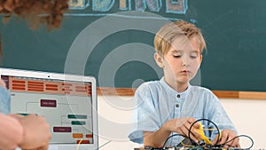 Caucasian boy fixing main board by using screwdriver at stem lesson. Pedagogy.