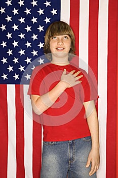 Caucasian boy with hand over heart with american flag background