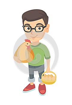 Caucasian boy holding a chicken and hen eggs.