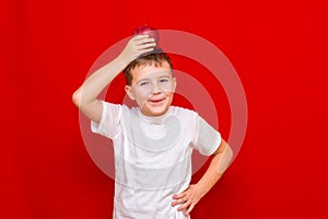 Caucasian boy kid child schoolboy holds a red Apple in his hands. Vitamins and fruits, healthy food. bright red wall