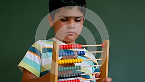 Caucasian boy learning mathematics with abacus against green board in classroom