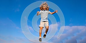 Caucasian boy in a park running and smiling on blue sky. Happy kid laughing. Emotion face joy child. Joyful, funny