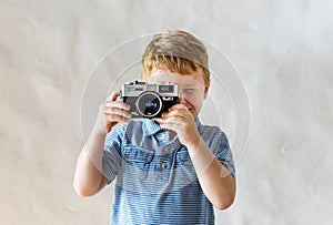 Caucasian boy playing with a camera