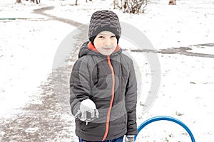 Caucasian boy sculpts snowballs, outdoor winter activities, sports concept