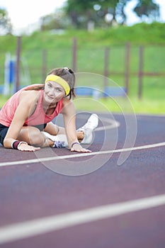 Caucasian Brunette Female in Athletic Sportgear Having Legs Stretching Excercises Outdoors