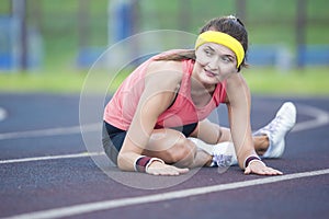 Caucasian Brunette Female in Athletic Sportgear Having Legs Stretching Excercises Outdoors