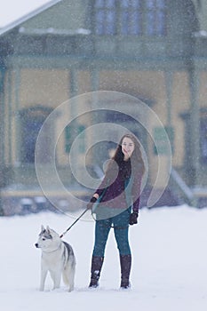 Caucasian Brunette Woman Keeping Her Husky Dog on a Short Leash During a Stroll