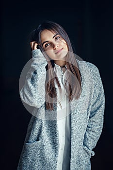 Caucasian brunette young beautiful girl woman model with dark hair and brown eyes in white shirt and grey long coat