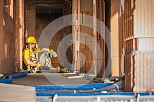 Caucasian Builder Worker Resting on the Floor