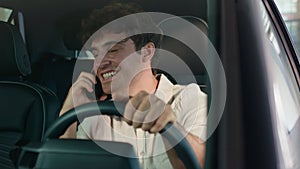 Caucasian business man driver male guy driving new luxury modern electric car talking mobile phone call smiling speaking