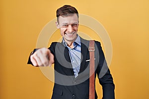 Caucasian business man over yellow background pointing to you and the camera with fingers, smiling positive and cheerful