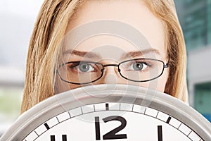 Caucasian business woman holding clock.