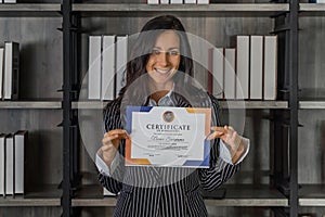 Caucasian business woman posing with certificate of appreciation recieved from business performace competition