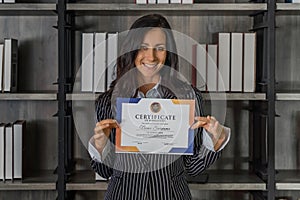 Caucasian business woman posing with certificate of appreciation recieved from business performace competition photo