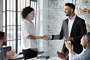 Caucasian businessman handshake greeting biracial female employee