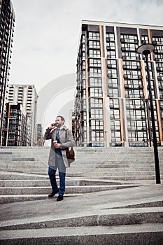 Caucasian businessman in a raincoat standing outdoors