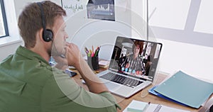 Caucasian businessman sitting at desk using laptop having video call with male colleague