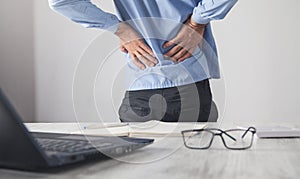 Caucasian businessman suffering from back pain in office