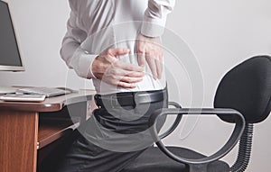 Caucasian businessman suffering from back pain in office