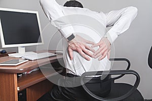 Caucasian businessman suffering from back pain in office