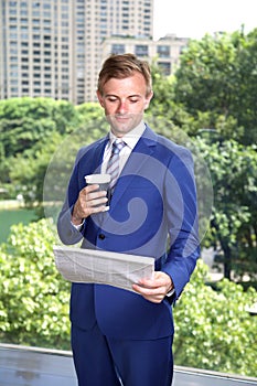 Caucasian businessman wearing suit reading newspaper