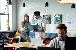 Caucasian businesswoman and african american businessman discussing strategy over file in office