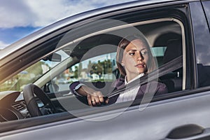 Caucasian businesswoman fastening car seat belt