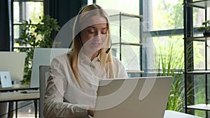 Caucasian businesswoman girl operator in headset working customer helpline service in call center online negotiation on