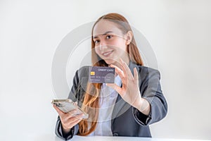Caucasian businesswoman hand hold mock-up credit card for online shopping on smartphone or laptop computers from home office,