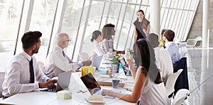 Caucasian Businesswoman Leading Meeting At Boardroom Table photo