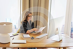 Caucasian businesswoman sitting at desk and using laptop in the office photo